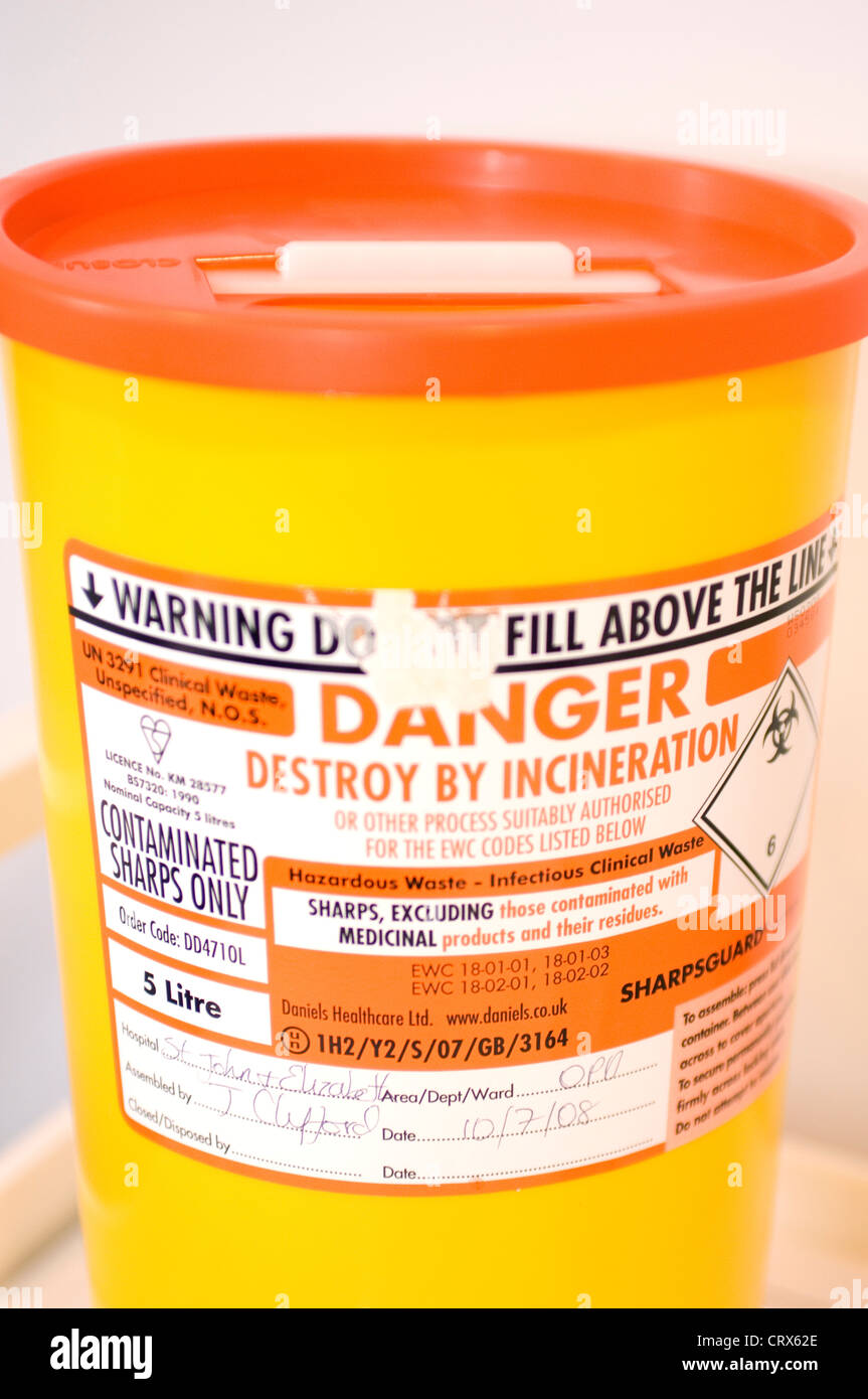 Un conteneur jaune pour l'élimination de 'sharps', abandonné des aiguilles utilisées pour leur donner des injections ou de prélever du sang. Banque D'Images