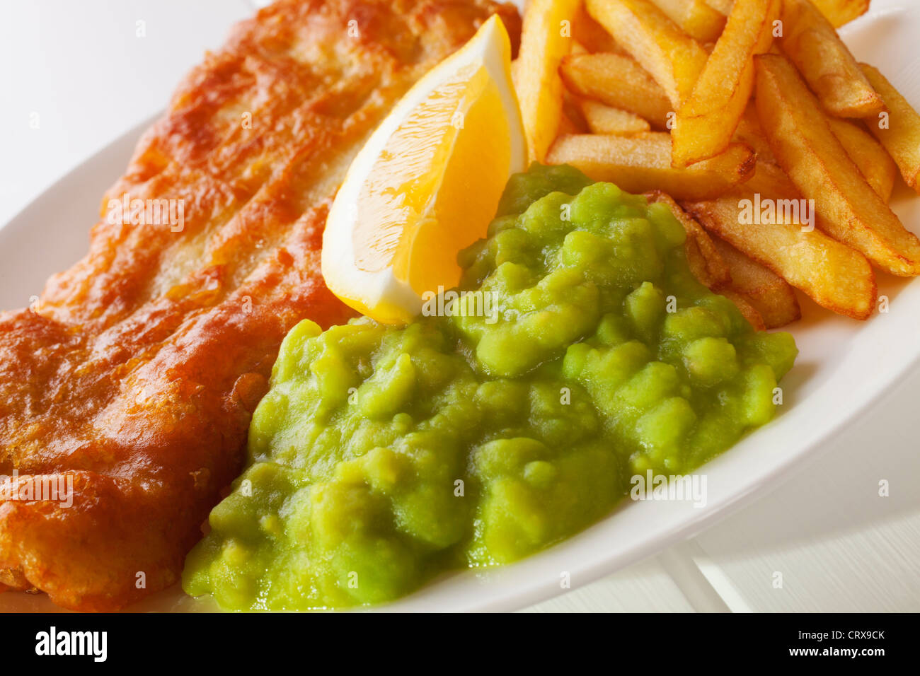 Petits pois servi avec frites et poisson, battues d'un quartier de citron. DOF peu profondes, gros plan Banque D'Images