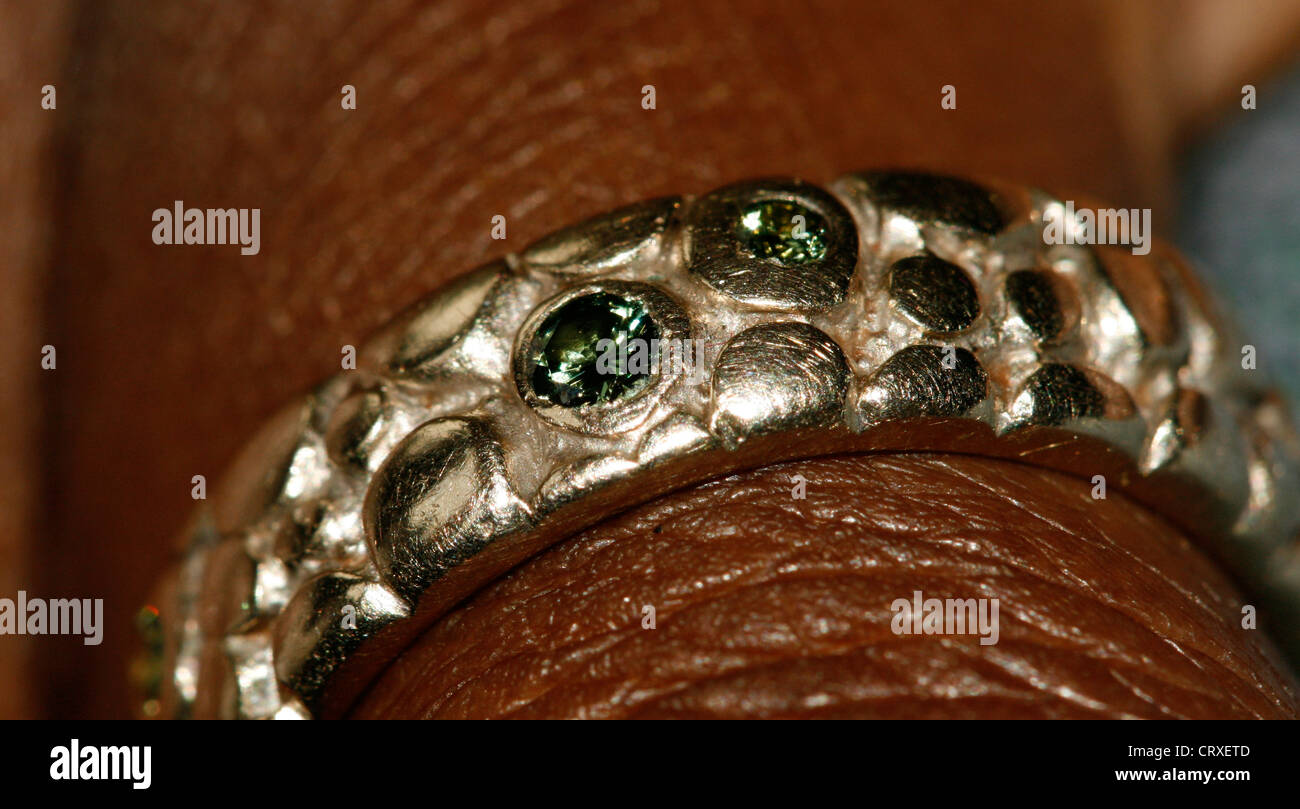 Une bague de mariage en or blanc avec diamants vert sur le doigt d'une femme africaine Banque D'Images