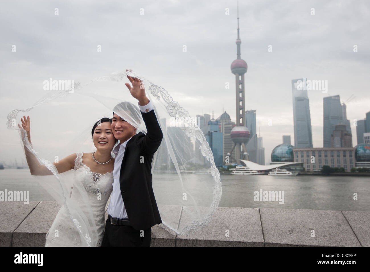 Les jeunes couples chinois ont tourné les photographies de mariage, début de matinée sur le Bund, avec en arrière-plan de Pudong, à Shanghai, Chine Banque D'Images