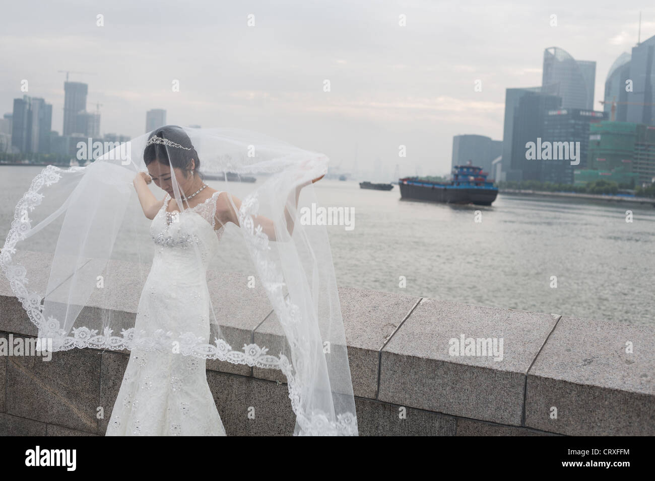 Les jeunes couples chinois ont tourné les photographies de mariage, début de matinée sur le Bund, avec en arrière-plan de Pudong, à Shanghai, Chine Banque D'Images