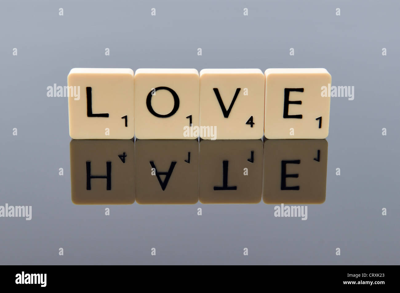 Scrabble lettres épelant le mot amour par le mot hate que sa réflexion, le concept d'une ligne fine entre l'amour et la haine Banque D'Images