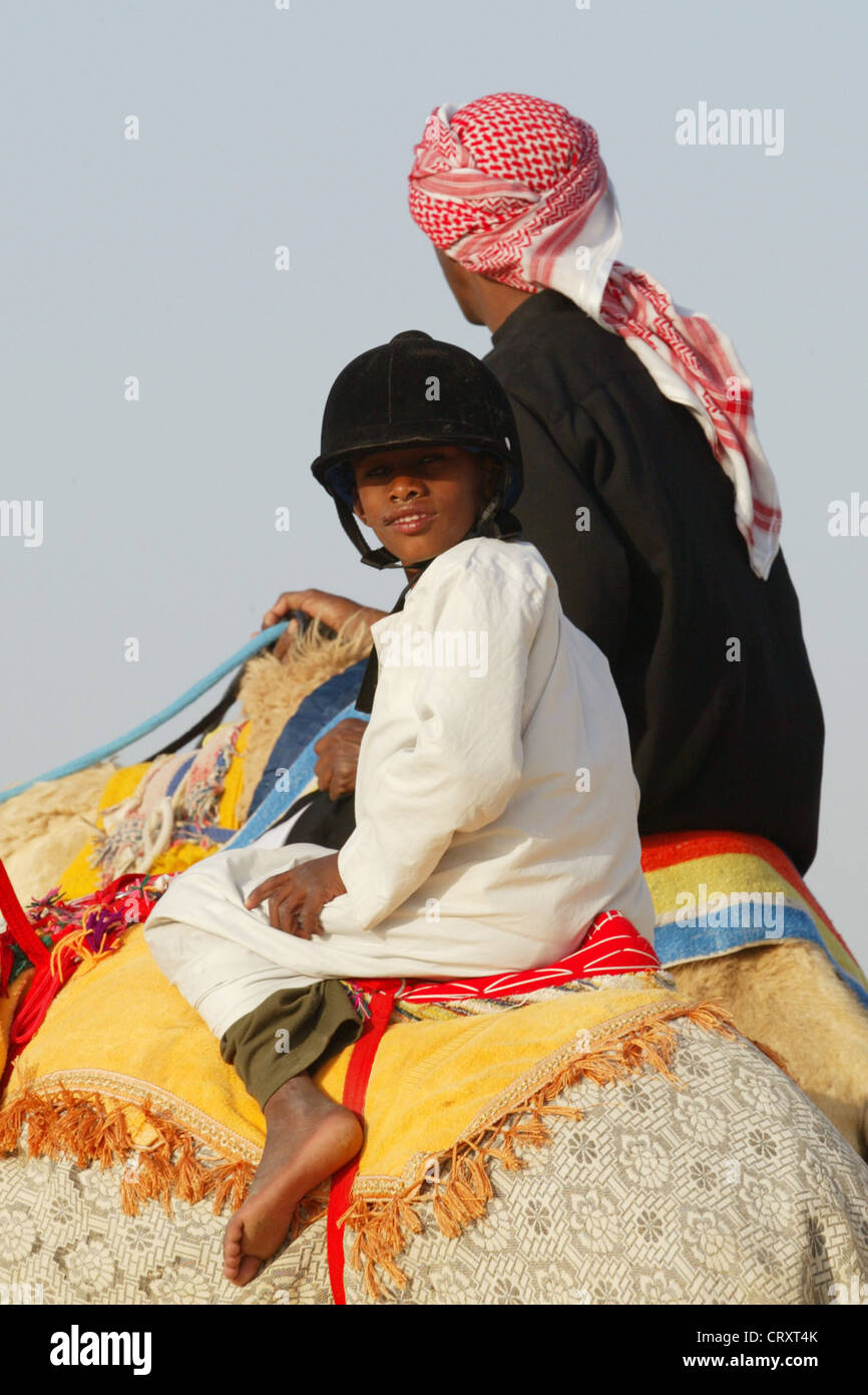 Un enfant à cheval sur un chameau, Dubaï Banque D'Images