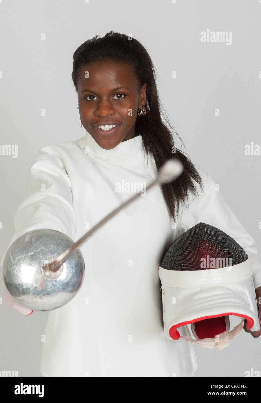 Tireur sportif de fille à l'épée et masque sur fond gris Banque D'Images