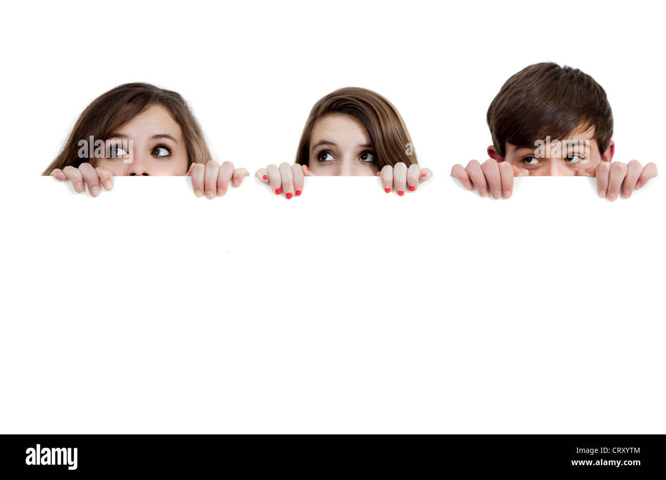 Trois adolescents peeking sur une board on white Banque D'Images