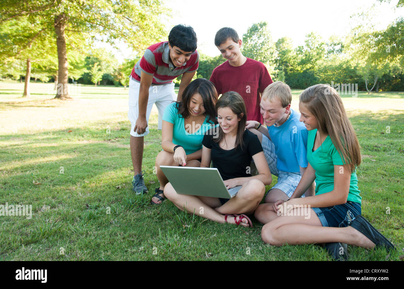 Divers Groupe d'adolescents à la recherche d'un ordinateur à l'extérieur Banque D'Images