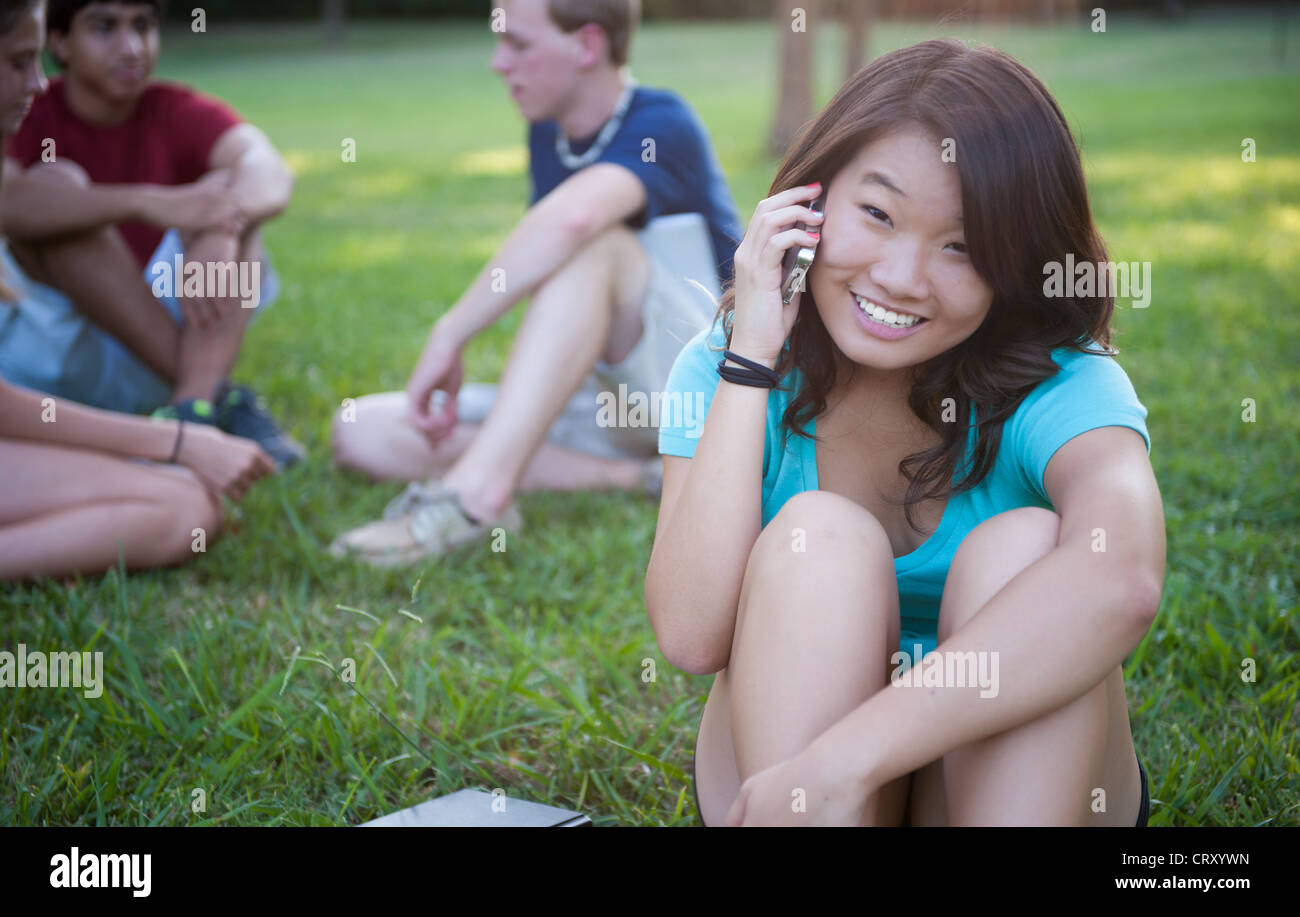 Teenage Asian girl parler au téléphone à l'extérieur Banque D'Images