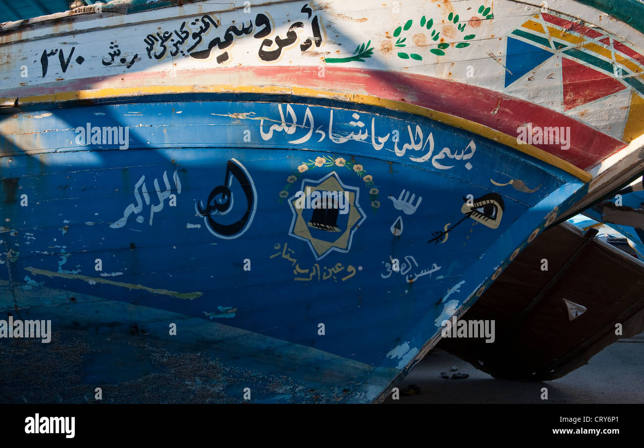 Un oeil protecteur et d'autres symboles peints sur un bateau de pêche utilisé par les réfugiés au port de Pozzallo, Sicile, Italie - les peintures sont loin de la malchance Banque D'Images