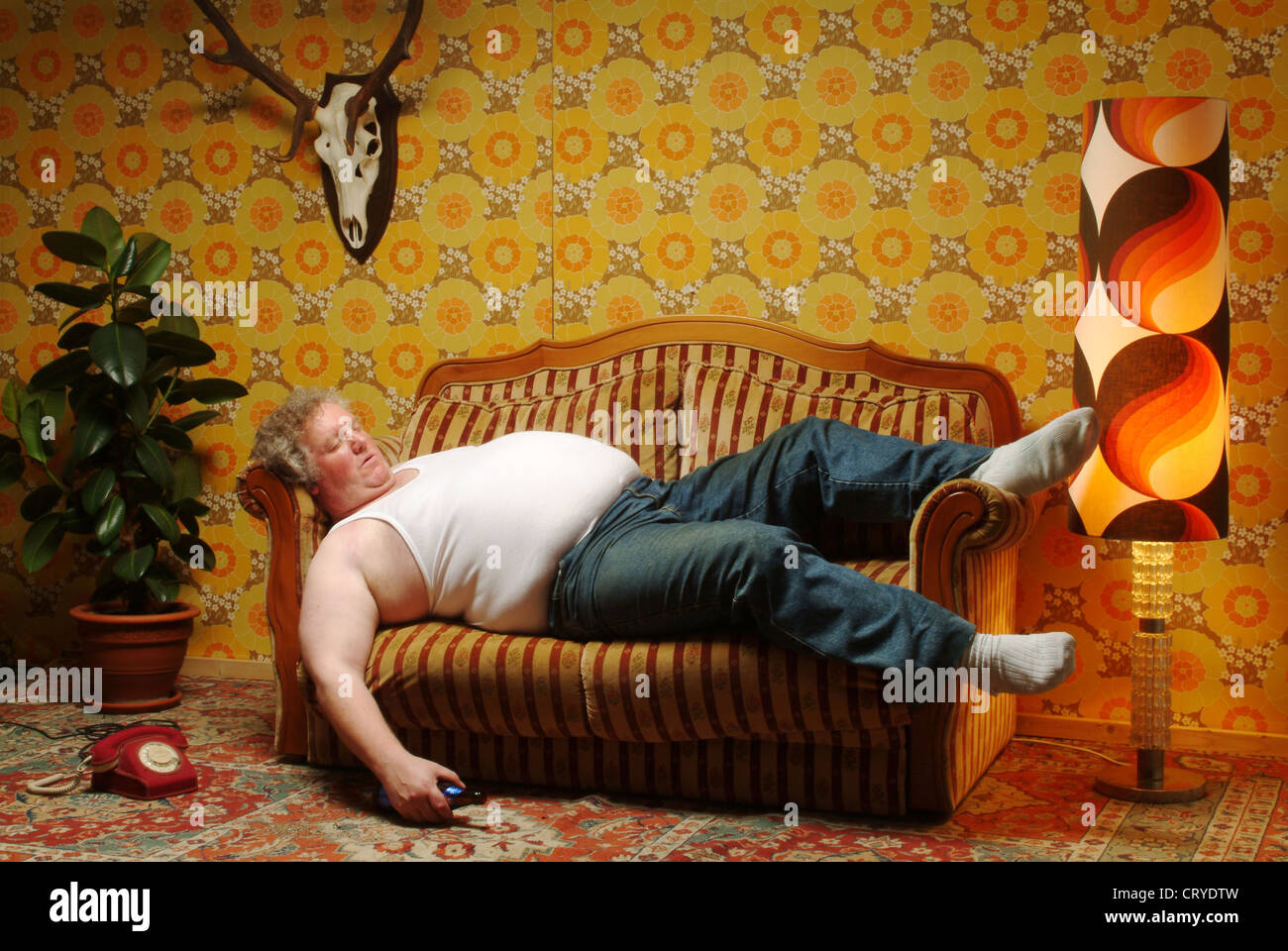 Gros homme en maillot de corps est en train de dormir sur le canapé Photo  Stock - Alamy