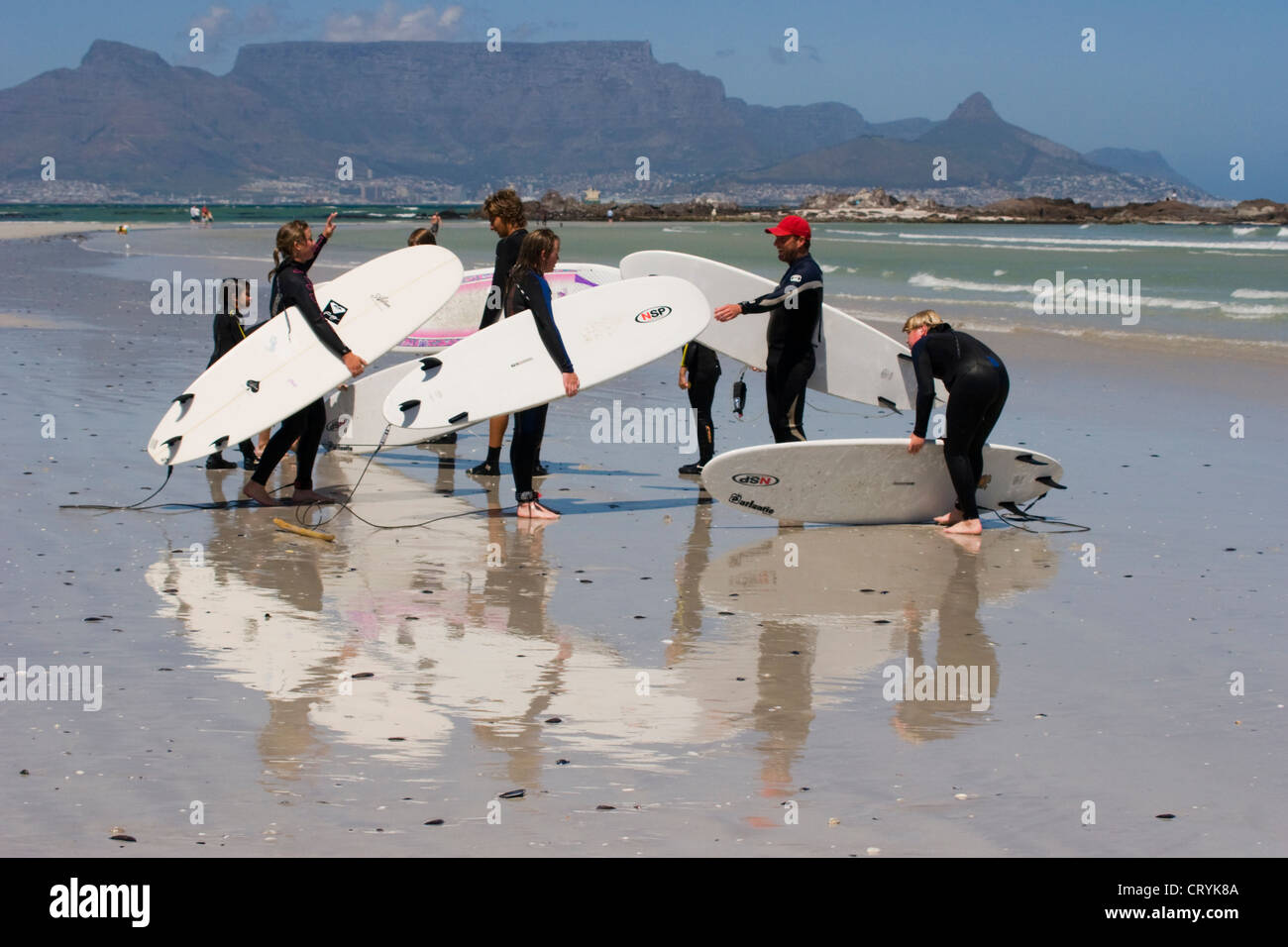 Surfers sur une plage du Cap avec la montagne de la table en arrière-plan Banque D'Images