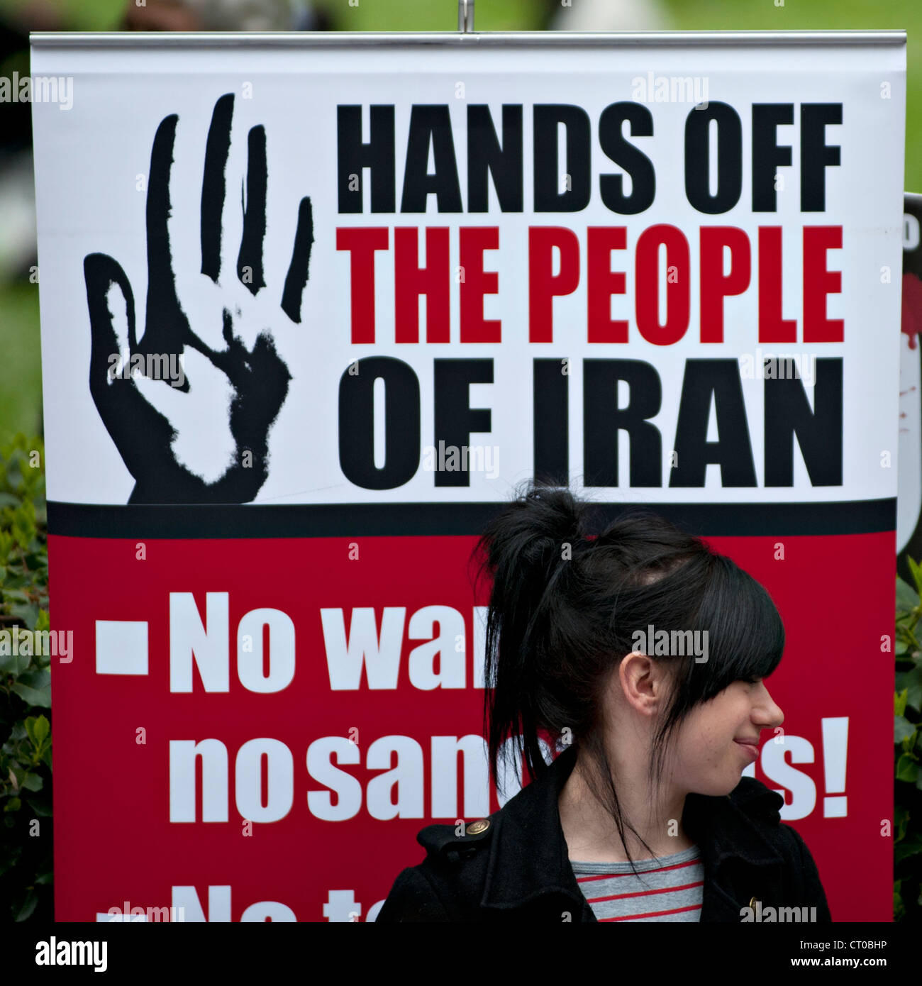 Un manifestant devant une bannière lors d'une coalition contre la guerre de protester contre l'intervention de l'OTAN au Moyen-Orient. Banque D'Images