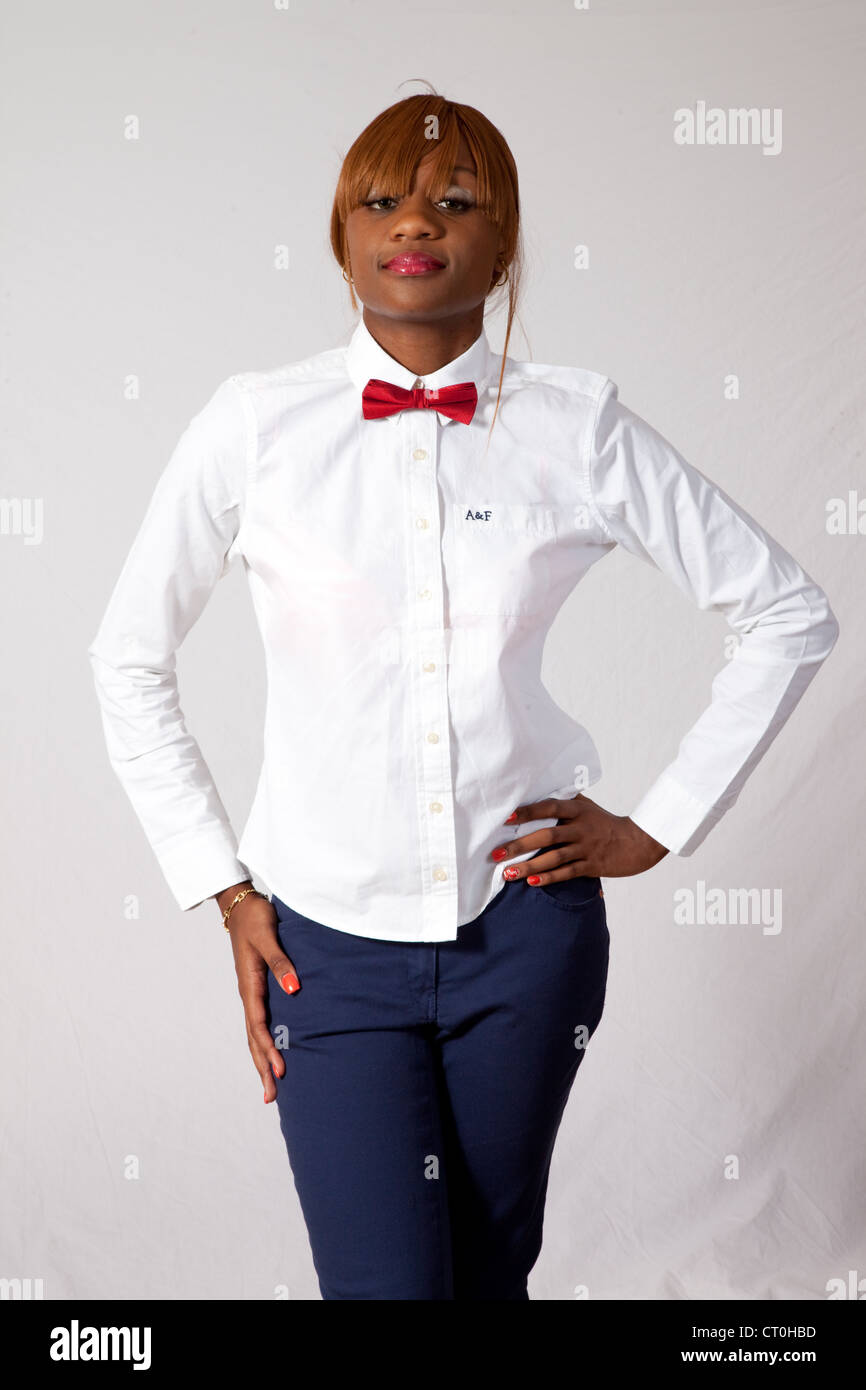 Jolie femme noire en chemise blanche, cravate rouge et bleu pantalon,  debout avec ses mains sur ses hanches et l'air sérieux Photo Stock - Alamy