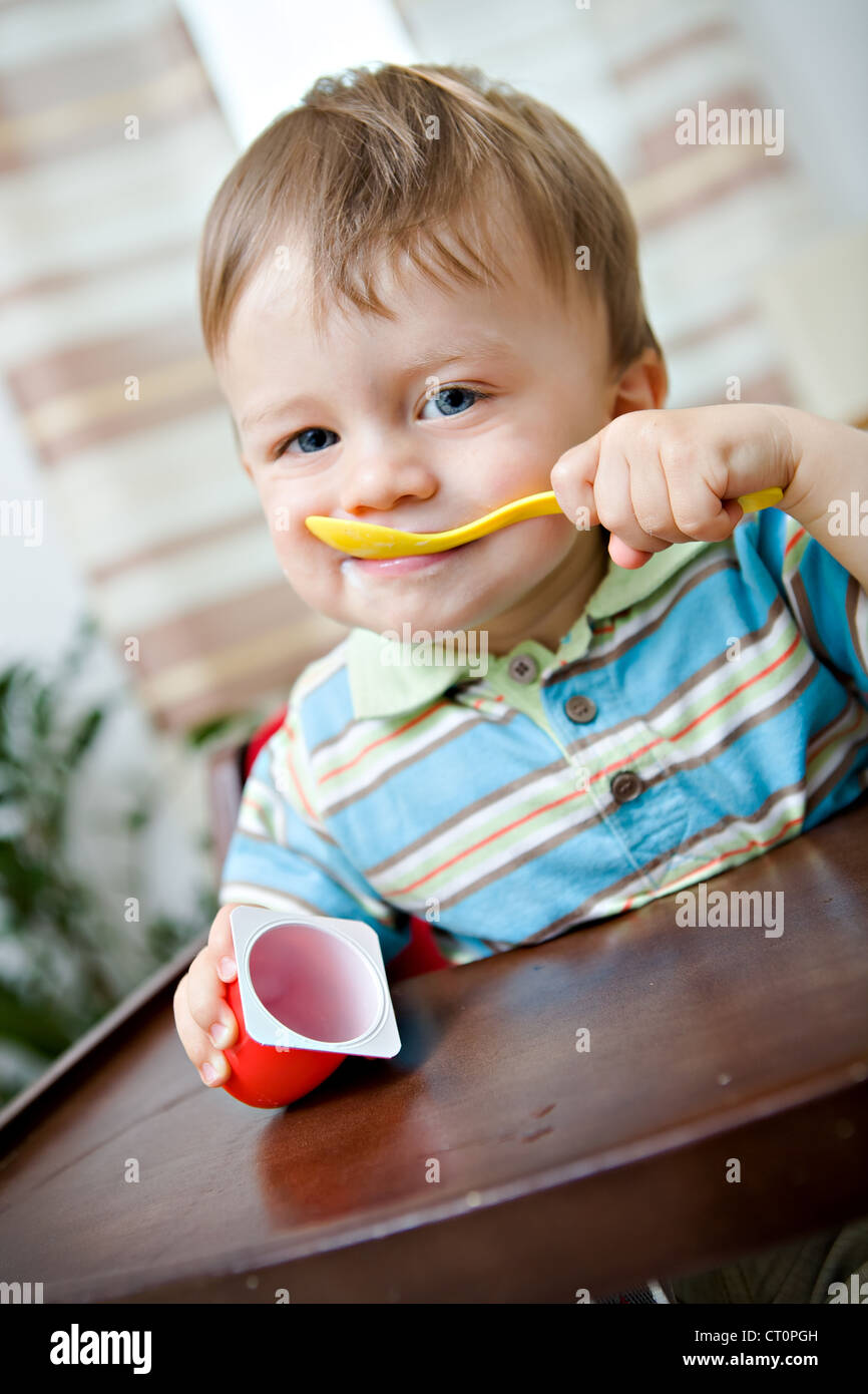 Petit enfant mangeant une yaourts Banque D'Images