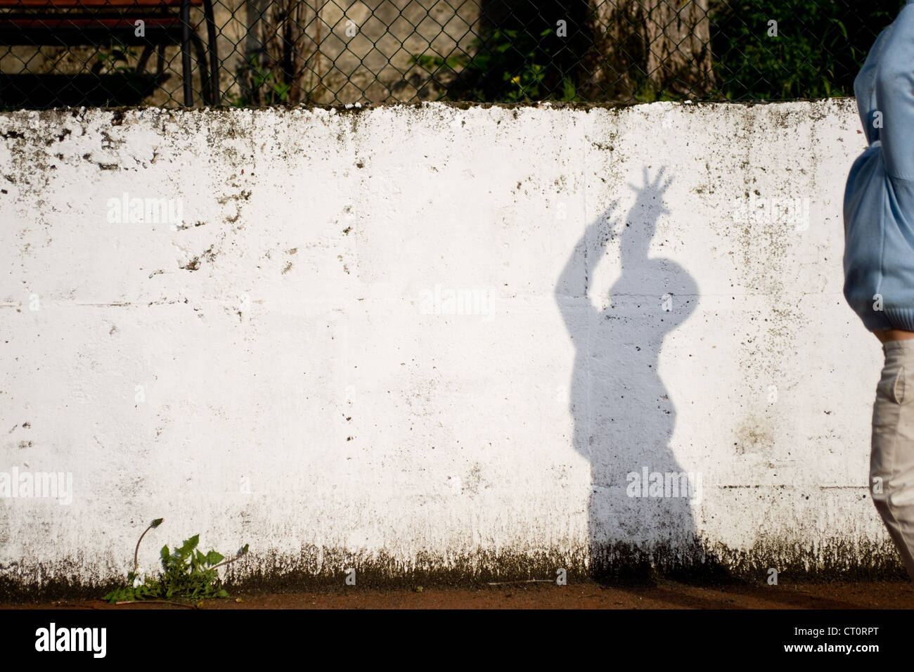 Ombre d'un garçon sur le mur jouer au ballon. Banque D'Images