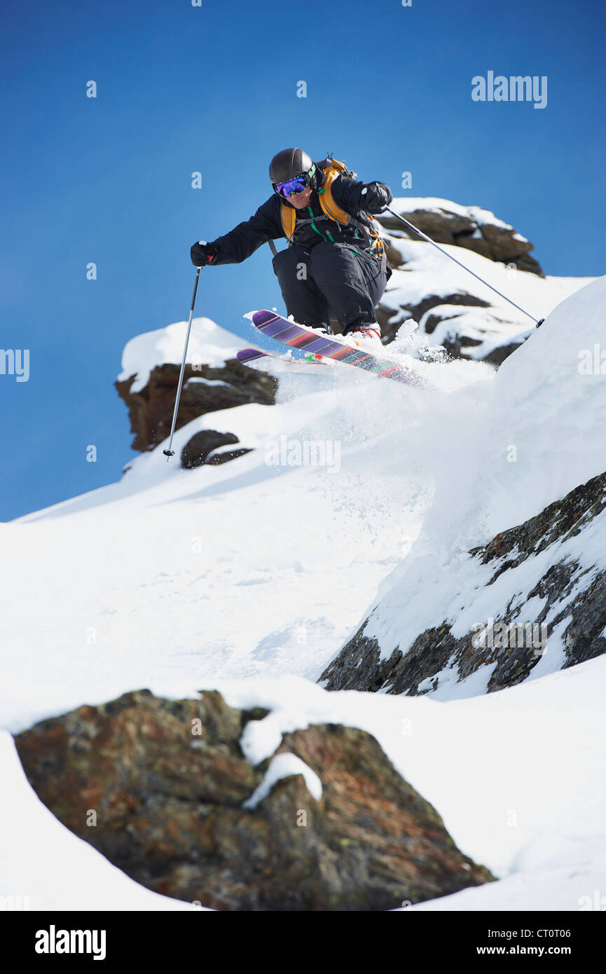 Skier Jumping off pente enneigée Banque D'Images