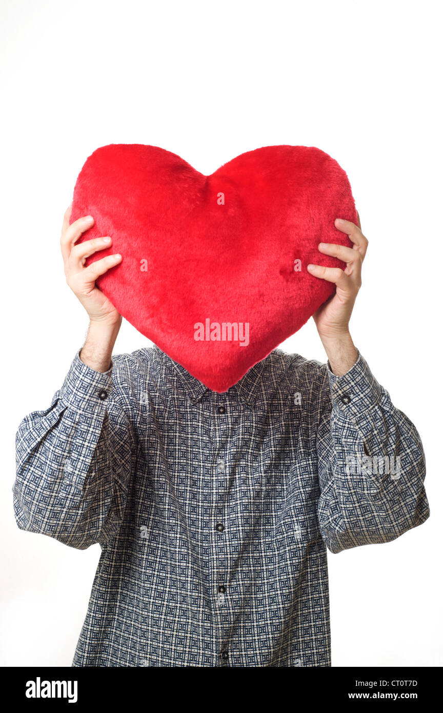 Homme tenant un oreiller en forme de coeur, l'amour et la Saint-Valentin concept Banque D'Images
