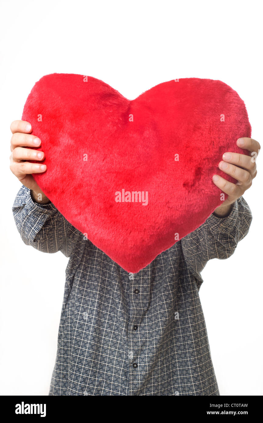 Homme tenant un oreiller en forme de coeur, l'amour et la Saint-Valentin concept Banque D'Images