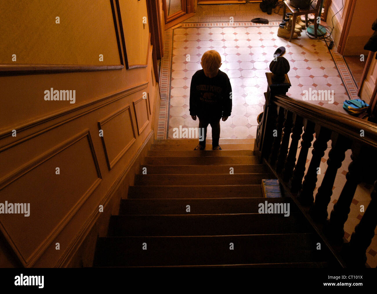 Un petit garçon est triste sur un escalier Banque D'Images