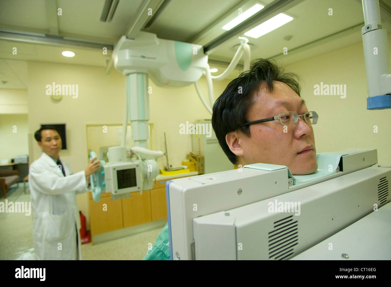 Un patient debout contre une plaque de plomb que le radiologue prend son x-ray. Banque D'Images