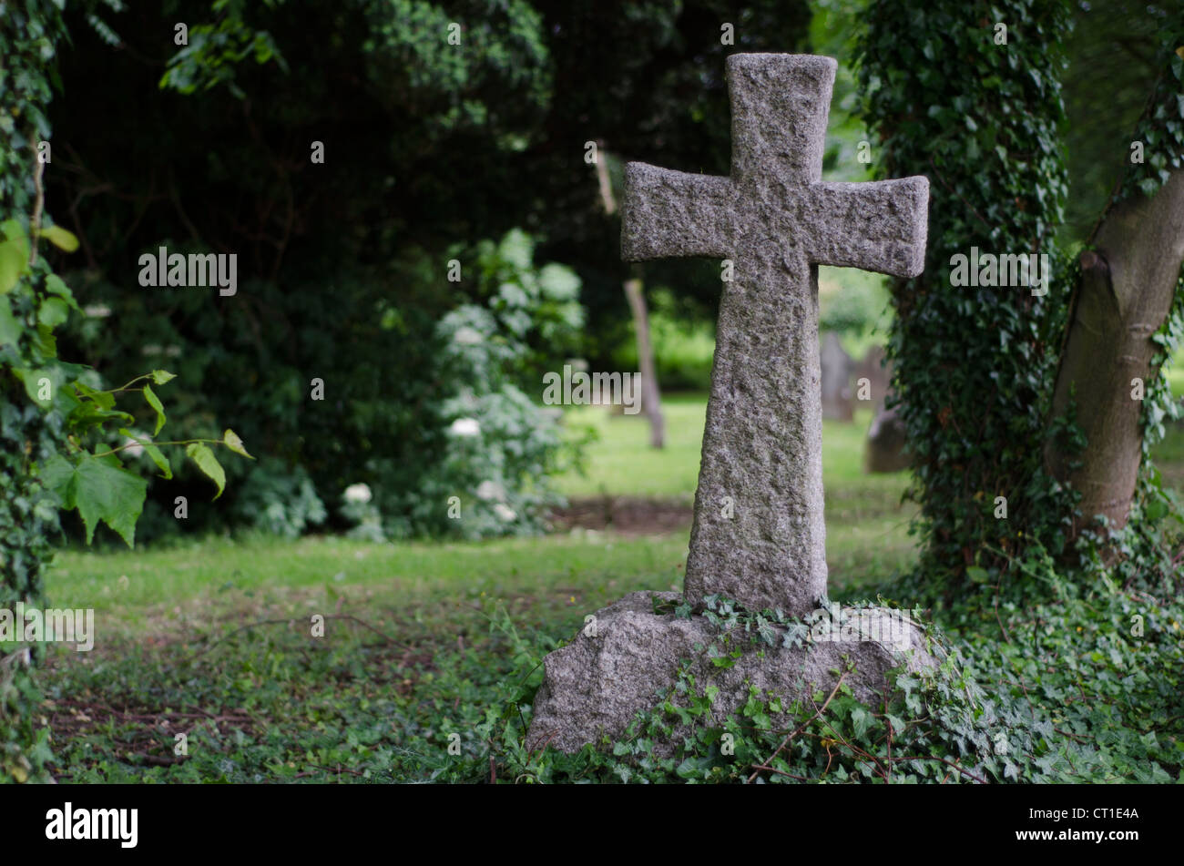 Une croix de pierre sur un angle dans un cimetière. Banque D'Images