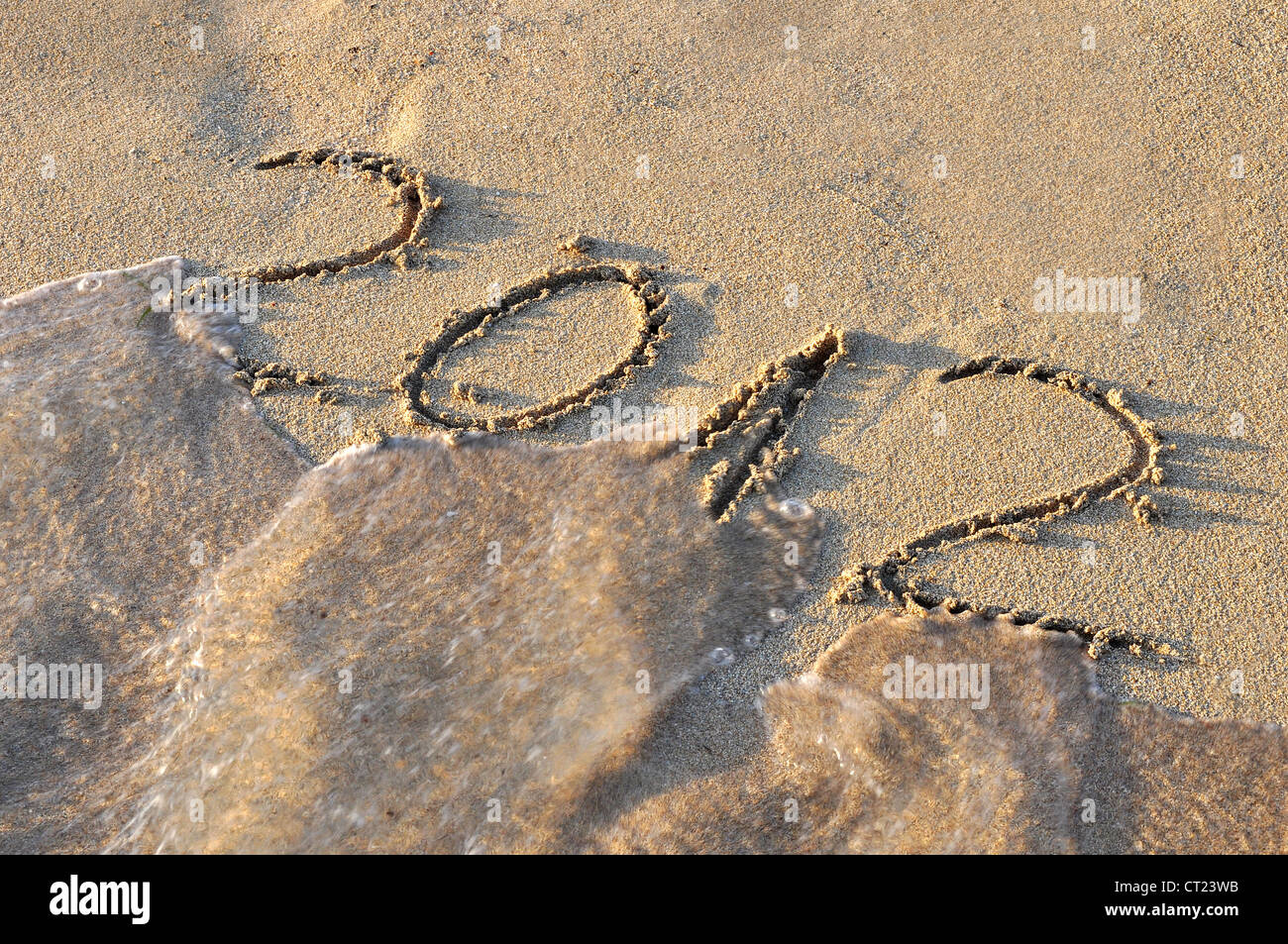 2012 écrit sur le sable, d'être emportés par la mer Banque D'Images