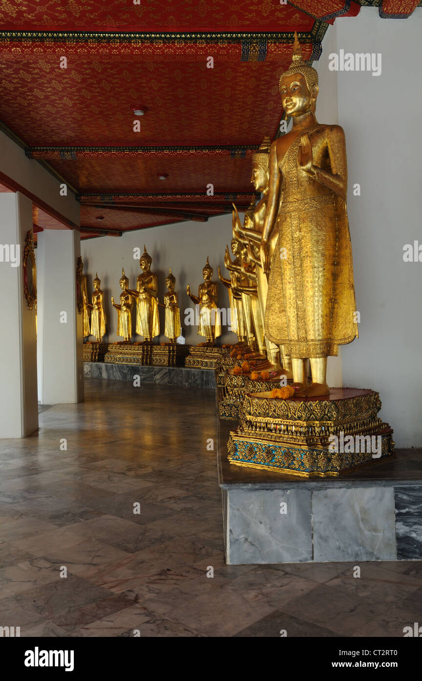 Temple Bouddhique Wat Po rangée de statues de Bouddha en or debout dans la position de protection Bangkok Thaïlande Banque D'Images