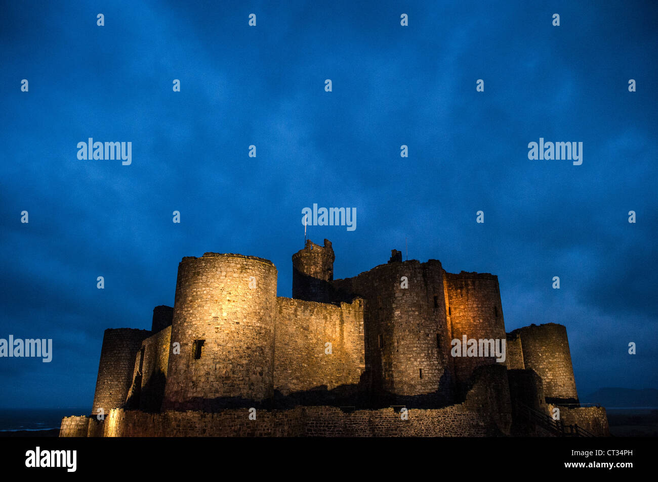 HARLECH, pays de Galles — le château de Harlech, une forteresse du XIIIe siècle construite par Édouard Ier, se dresse sur la côte nord-ouest du pays de Galles. La lumière qui s'estompe accentue le contour imposant de ce site classé au patrimoine mondial de l'UNESCO, mettant en valeur sa position stratégique surplombant la mer d'Irlande et évoquant la grandeur médiévale de ce monument historique. Banque D'Images