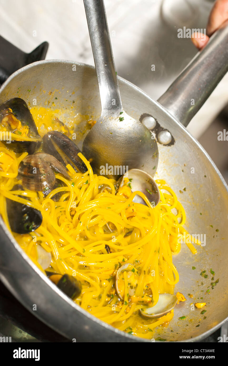 Spaghetti aux moules, palourdes et le safran dans une poêle. Banque D'Images