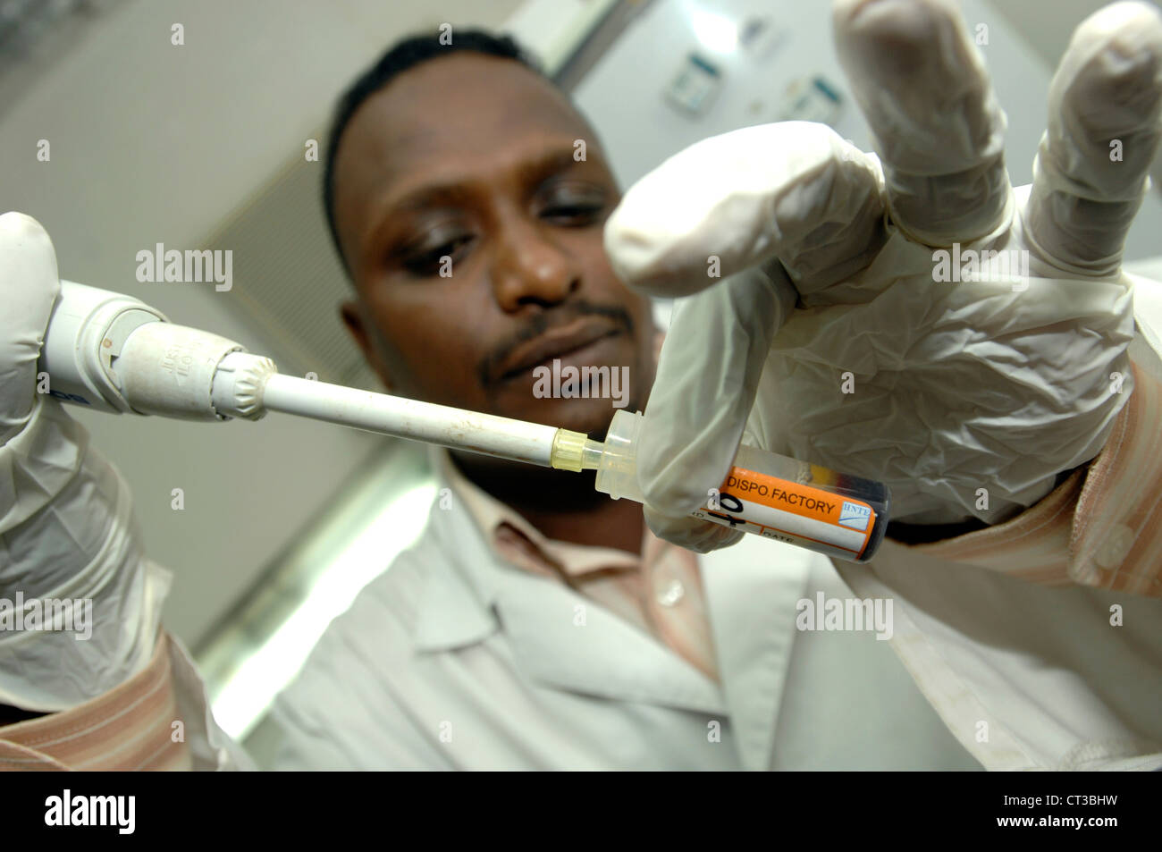 Un technicien de laboratoire distribue de liquide dans un tube échantillon. Banque D'Images