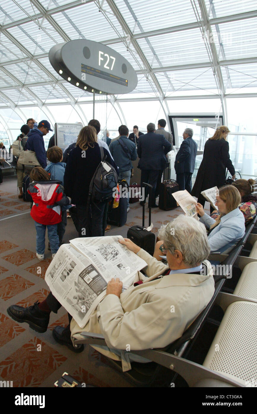 Paris, lire le journal en attente à l'aéroport Banque D'Images