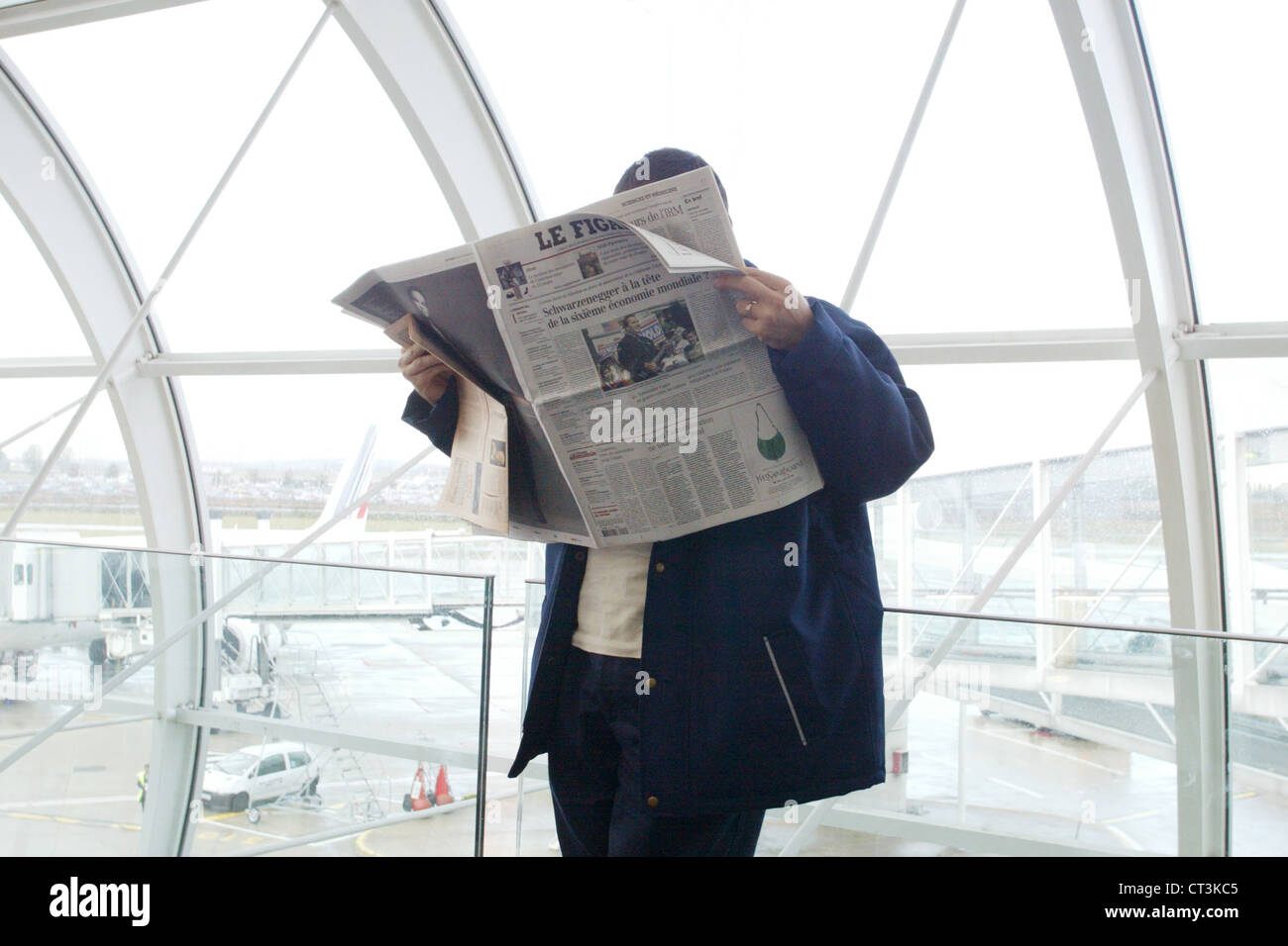 Paris, un journal se lit d'attente à l'aéroport. Banque D'Images