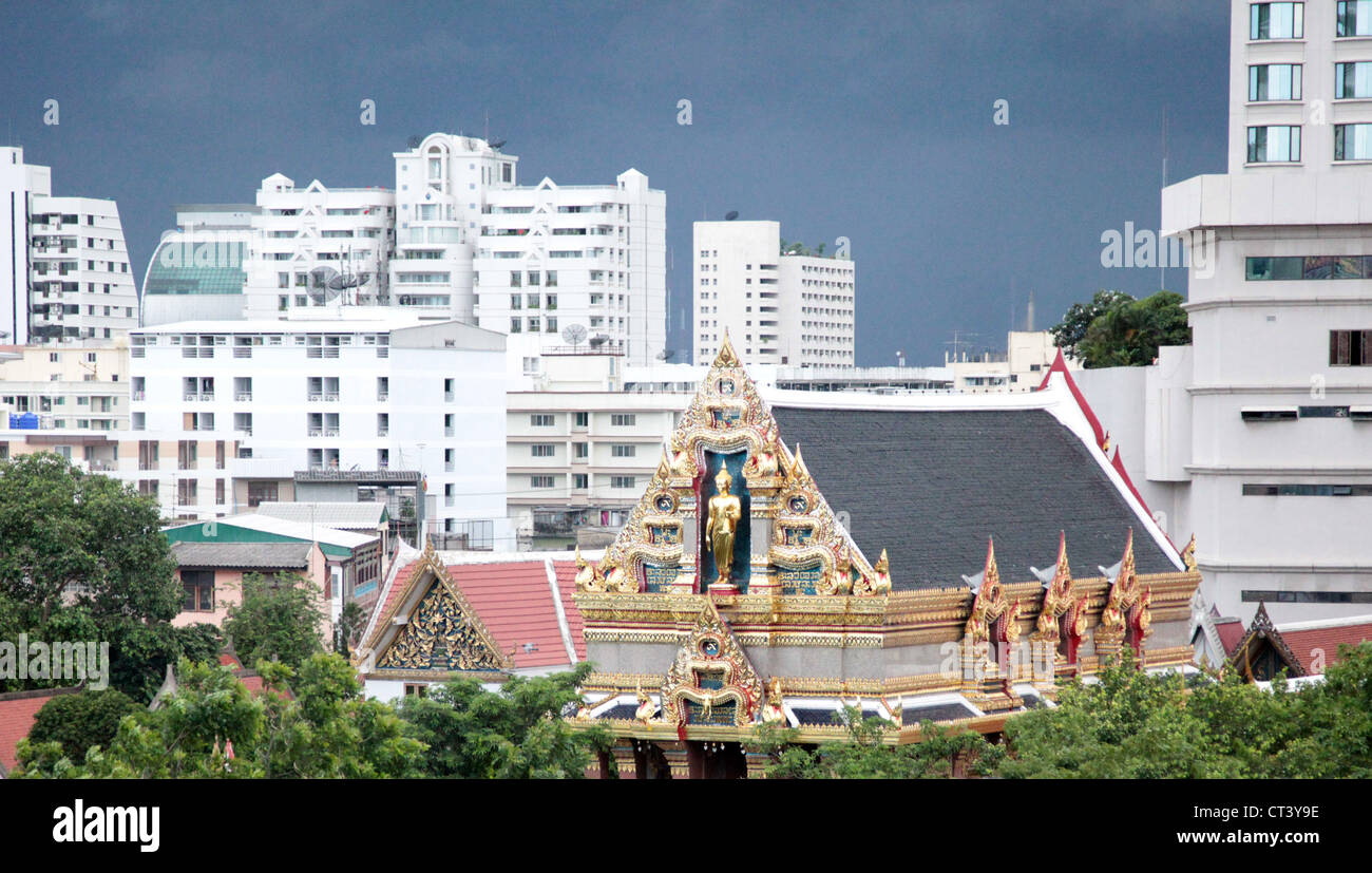 C'est une photo d'un temple thaïlandais bouddhiste au milieu de bâtiments modernes à Bangkok en Thaïlande. Il est typique de l'architecture Thaï Banque D'Images