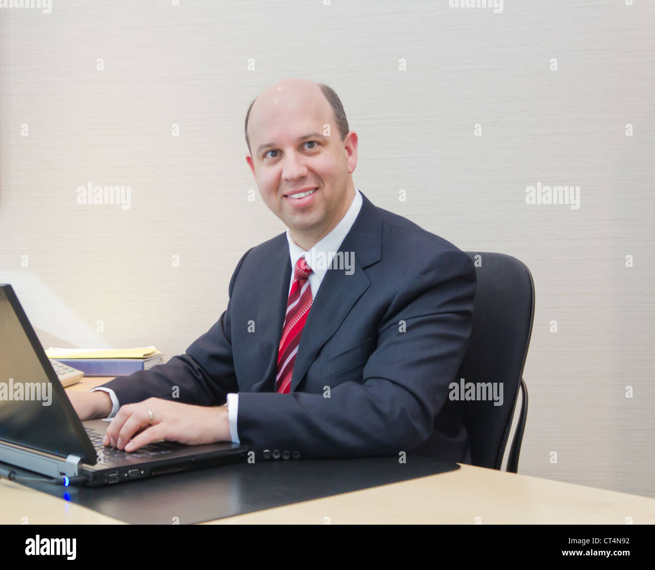 Smiling business man working on a laptop Banque D'Images