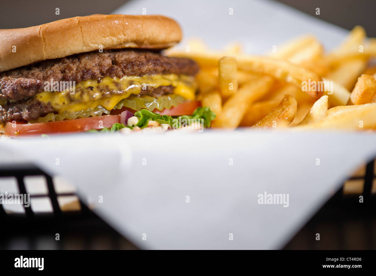 Un cheeseburger dans un panier de frites. Banque D'Images