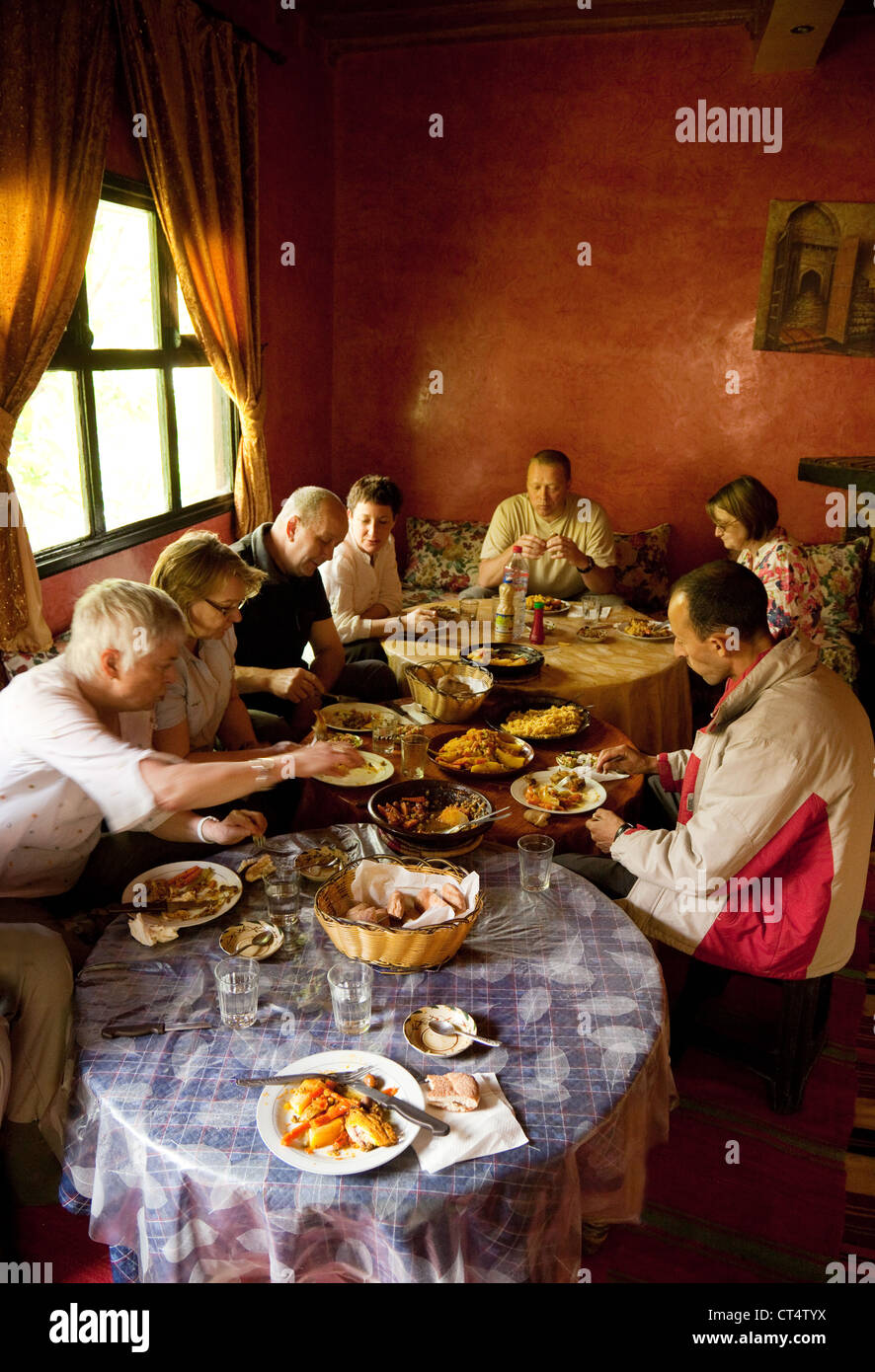 Les touristes ayant un repas traditionnel dans une maison berbère, Haut Atlas, Maroc Sud Banque D'Images