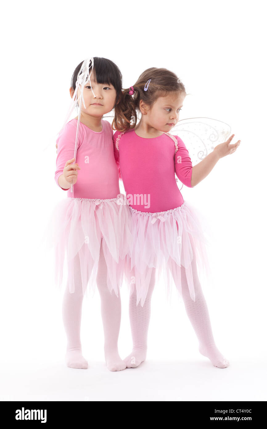 Deux jeunes filles portant des tutus rose tourné en studio sur un fond blanc. Banque D'Images