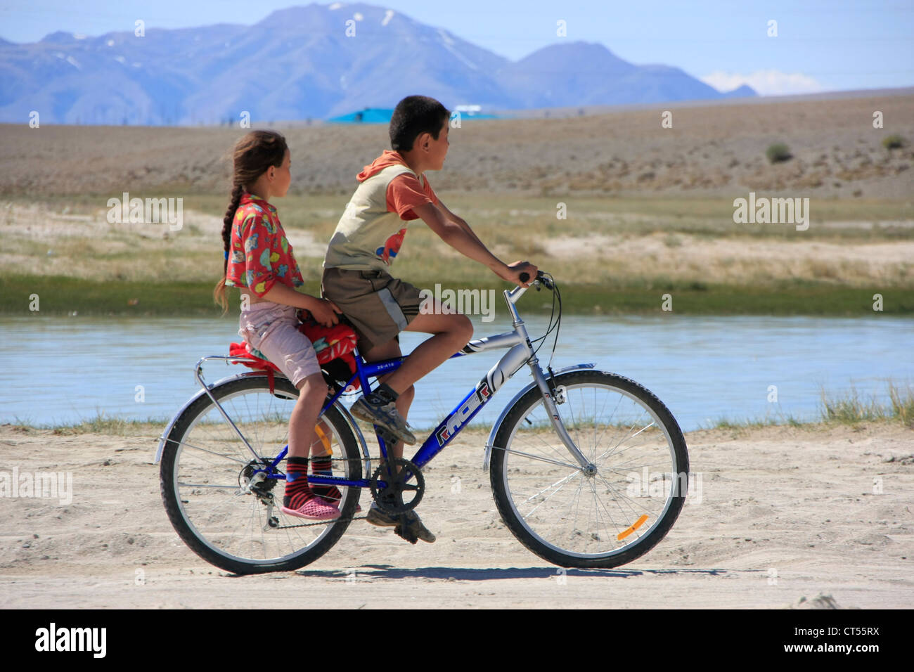 Enfants sur vélo à haut plateau du lac, Kosh-Agach, l'Altaï, Sibérie, Russie Banque D'Images