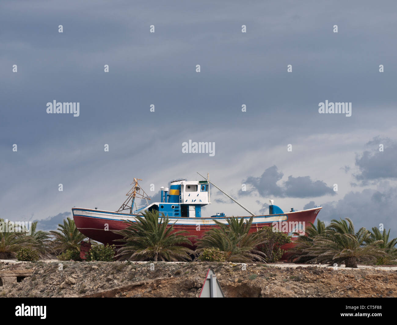 Bateau de pêche sur la terre sèche, élément décoratif dans une intersection sur la route principale, vu à Tenerife Espagne Banque D'Images