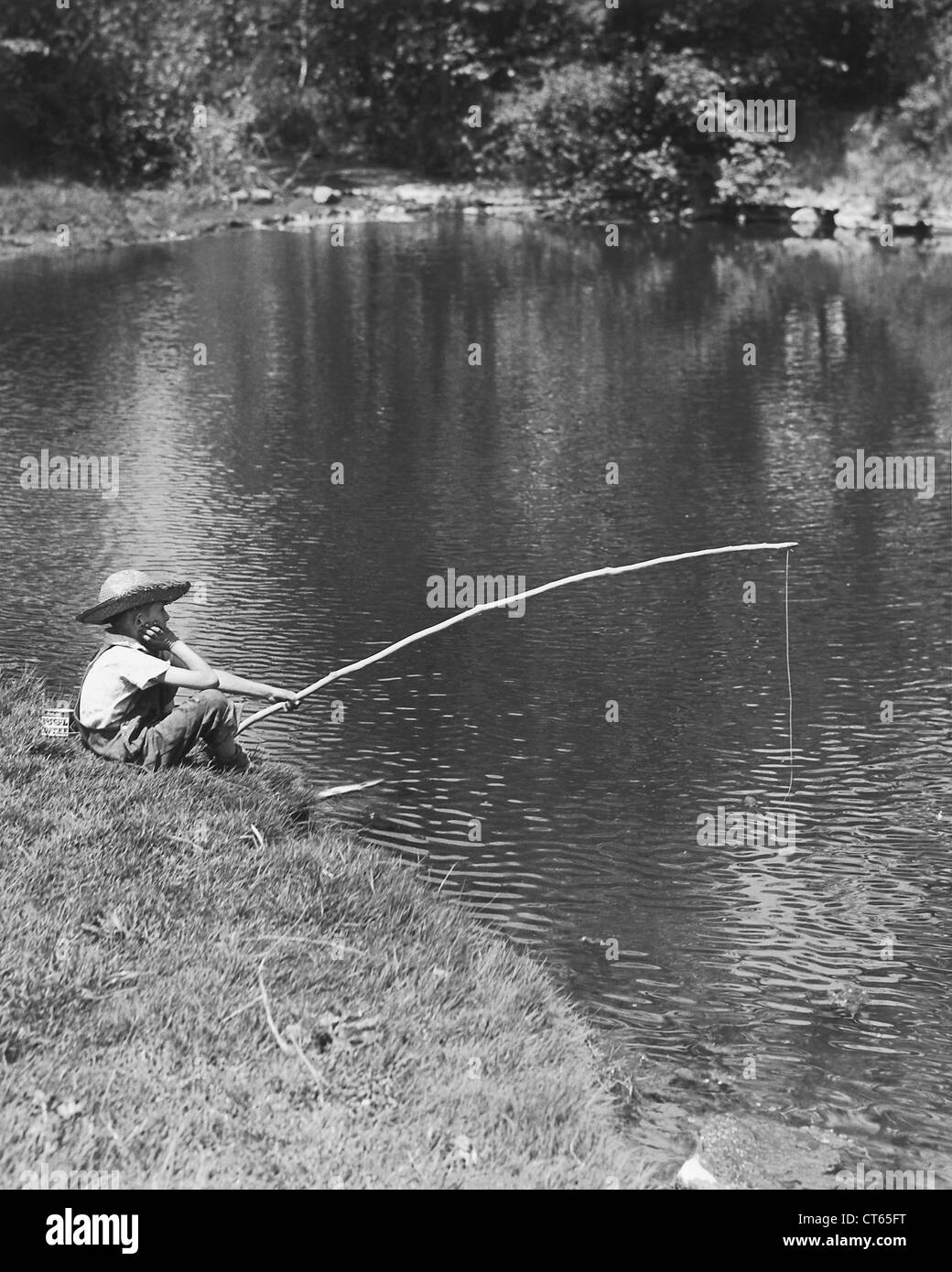 Garçon dans la pêche du chapeau de paille Banque D'Images