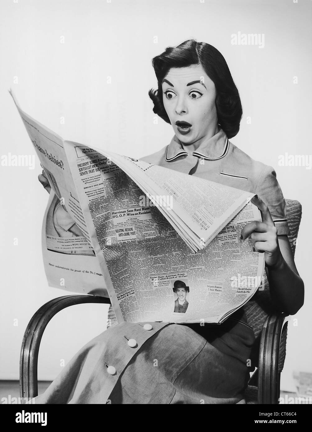 Surpris woman reading newspaper Banque D'Images