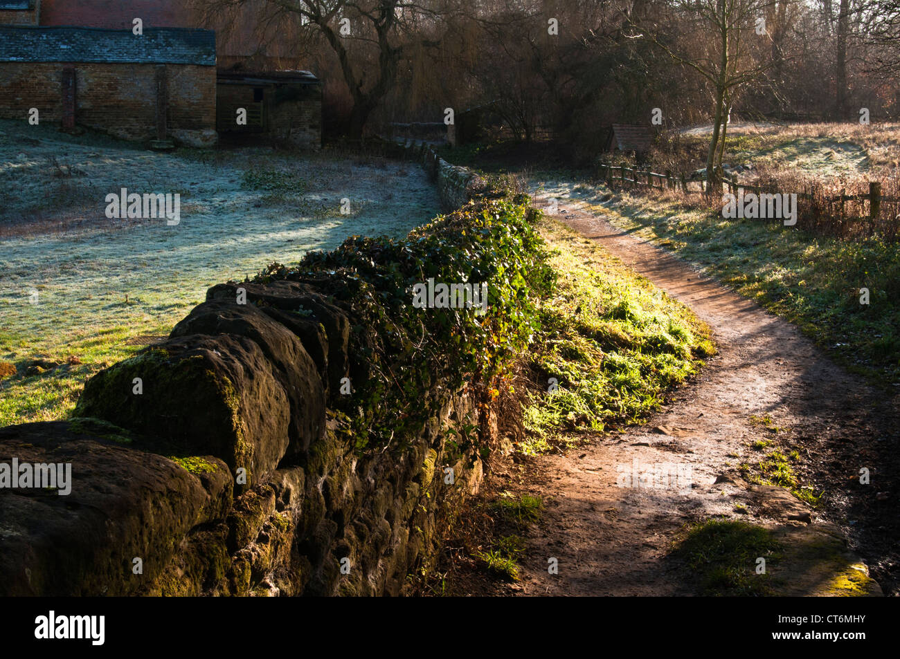 Un sentier mène à des bâtiments de ferme sur un matin glacial de janvier à Harlestone, Northamptonshire, Angleterre Banque D'Images