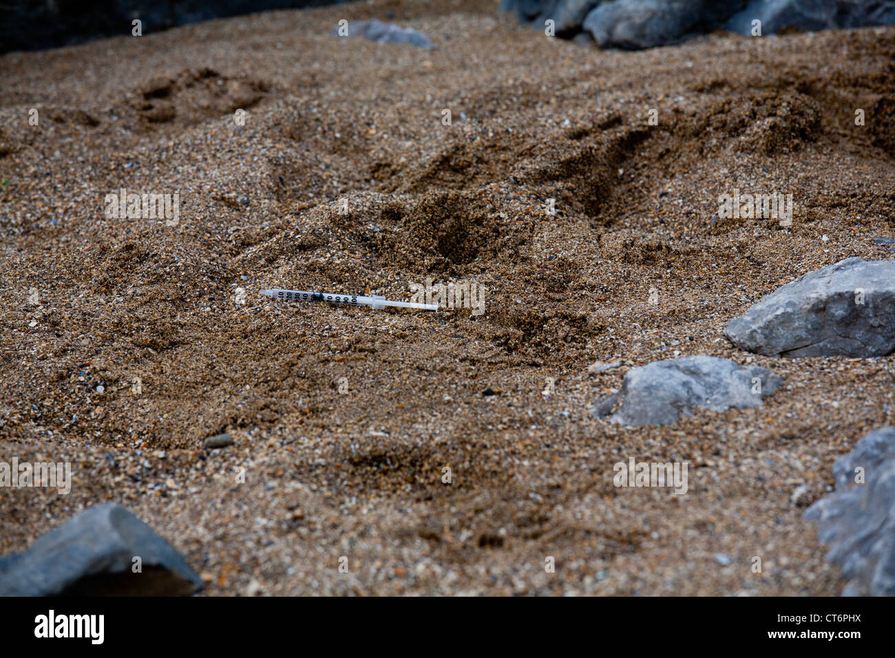 Seringue hypodermique jetés sur la plage dans le sable Banque D'Images