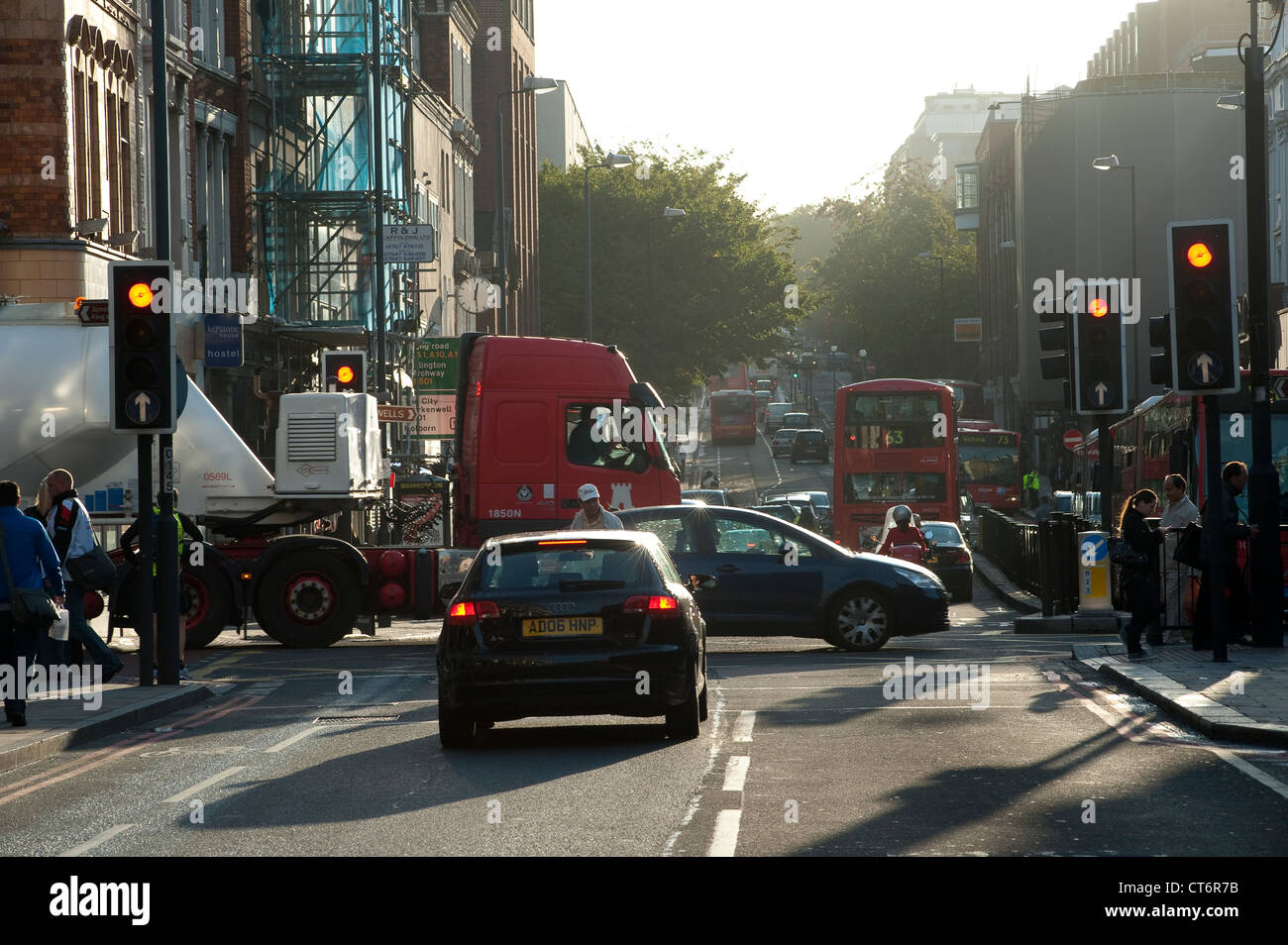 Attente du trafic à un feu rouge sur une longue rue de Londres au début de la matinée, en Angleterre. Banque D'Images