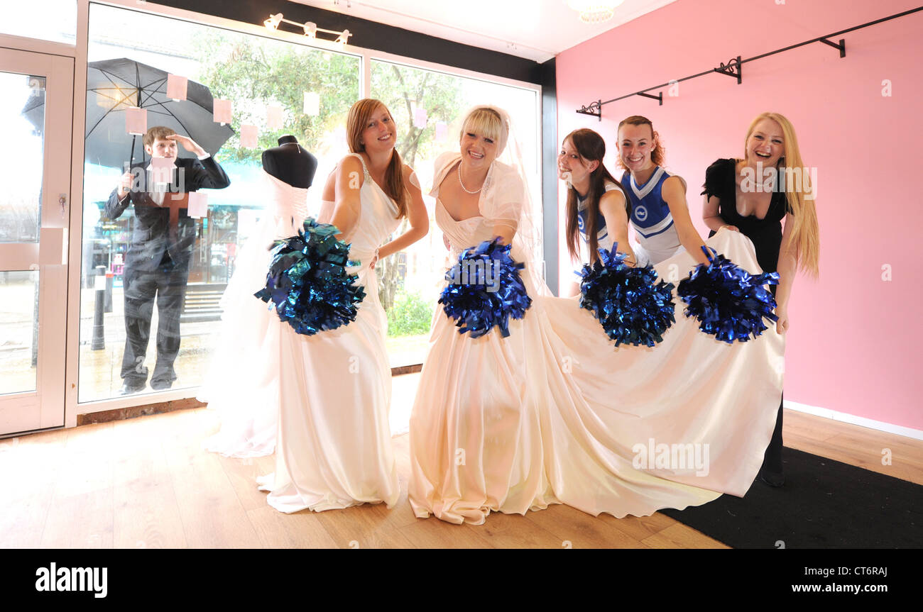 Propriétaire de magasin nuptiale avec les membres de football filles Gullys cheerleaders comme modèles Brighton UK Banque D'Images