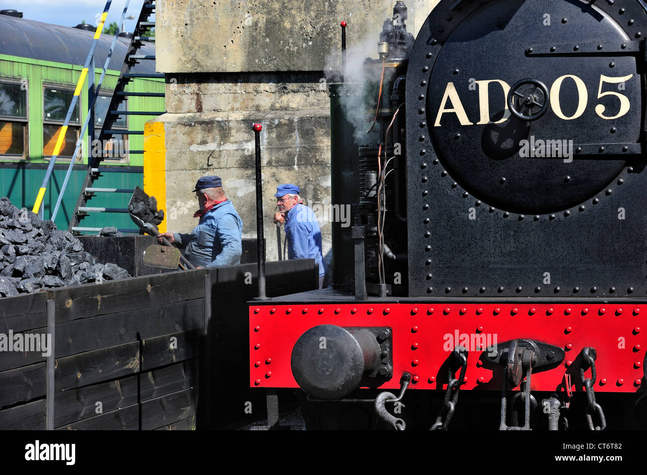 Les hommes chargement de charbon comme combustible pour les trains à vapeur au dépôt du Chemin de fer à vapeur des Trois Vallées à Mariembourg, Belgique Banque D'Images