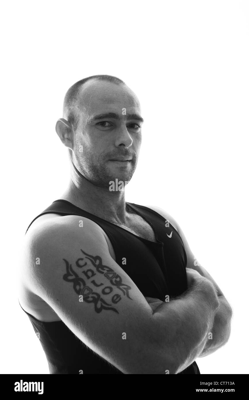 Jeune homme pose et montre un tatouage à sa salle de sport locale Banque D'Images