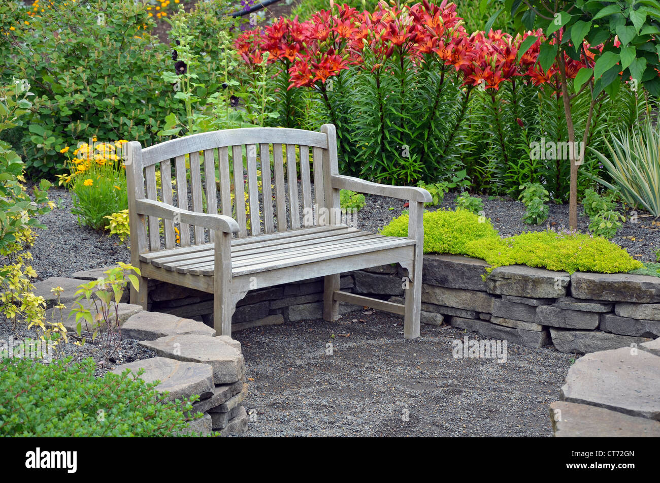 Banc en bois dans le jardin fleur de lys Banque D'Images