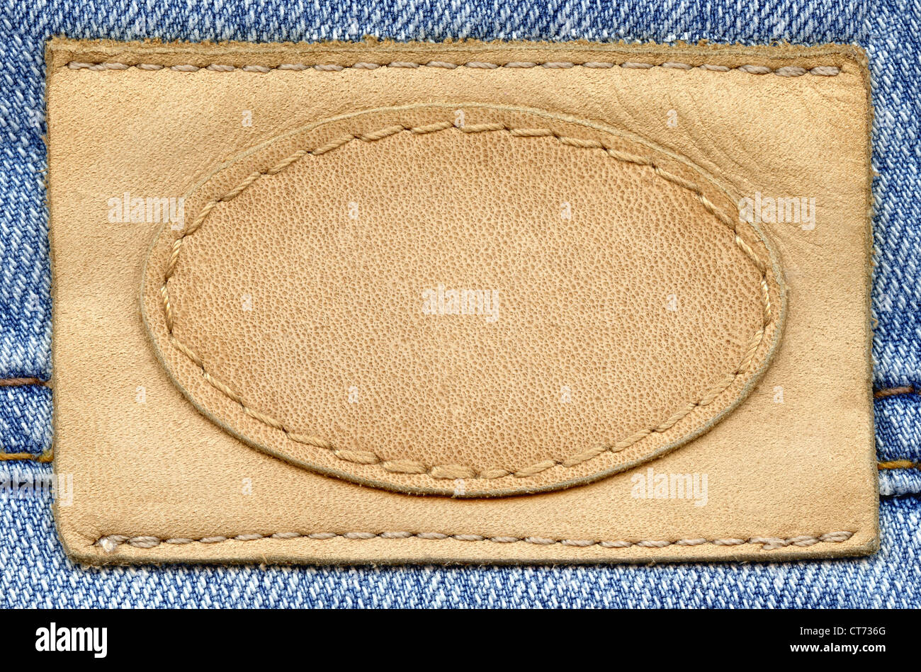 Étiquette de jean en cuir blanc cousue sur un jean bleu. Peut être utilisé comme arrière-plan de votre texte. Banque D'Images