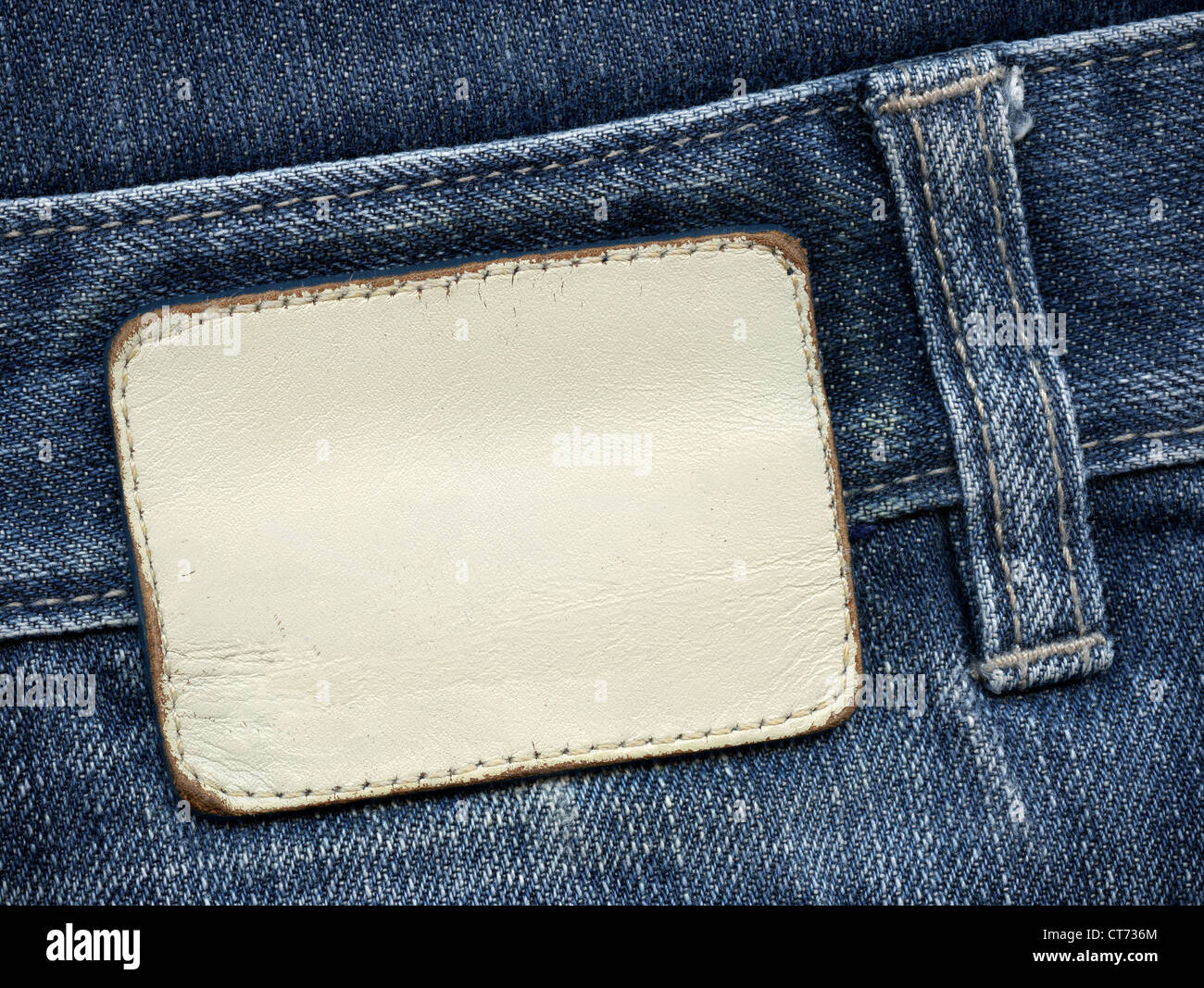 Étiquette de jean en cuir blanc cousue sur un jean bleu. Peut être utilisé comme arrière-plan de votre texte. Banque D'Images