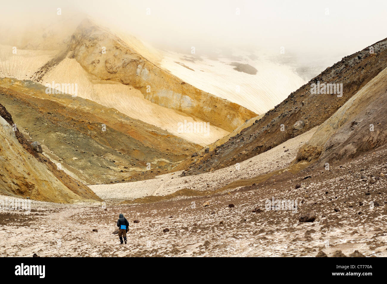 Randonneur marchant à travers canyon dont la teneur en soufre dans les sédiments de volcan Mutnovsky sur Kamchatka Banque D'Images